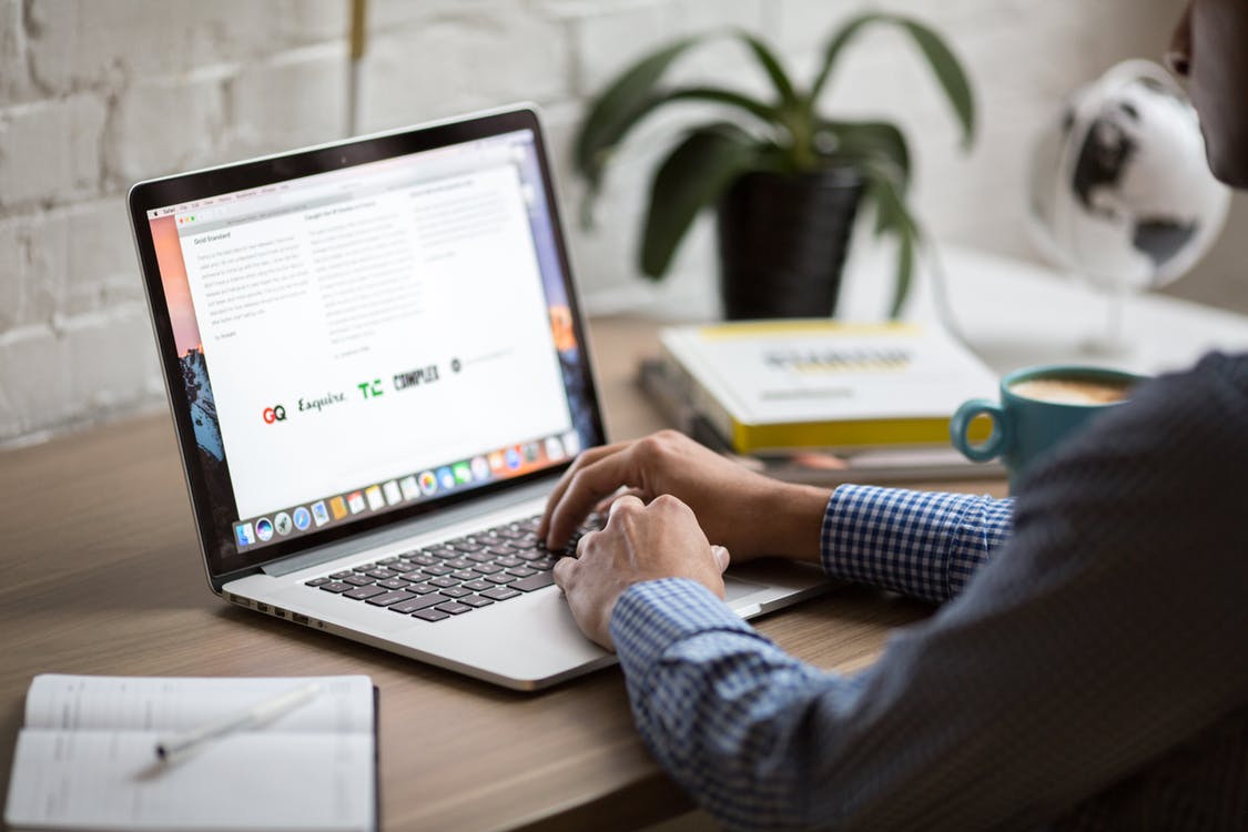 man at desk with mackbook