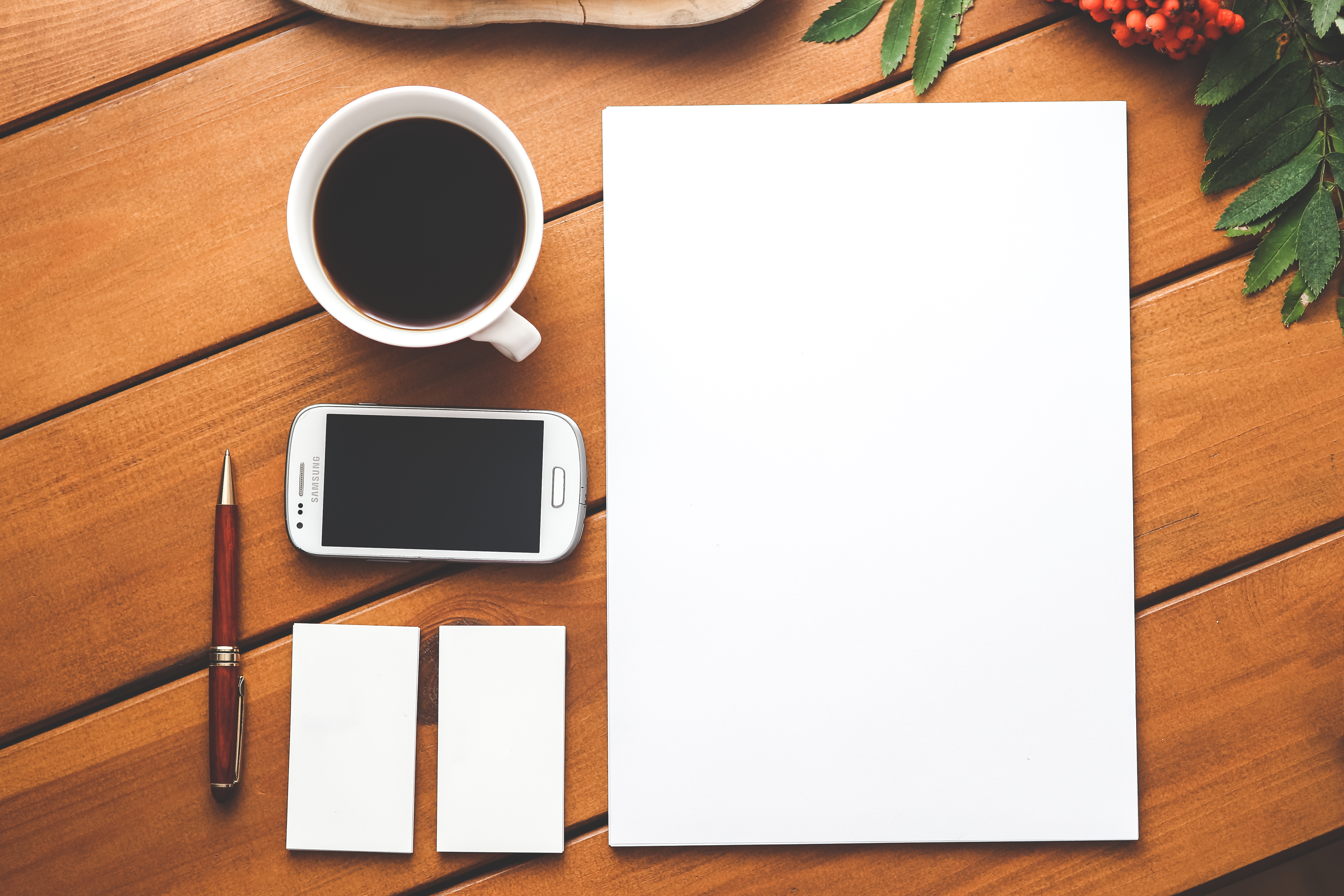 Notebook, phone, coffee and desk in business setting